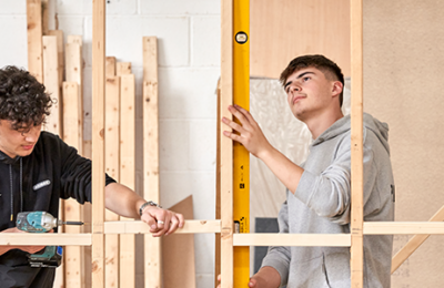 two male students building a wooden frame