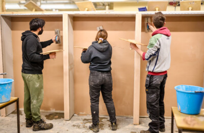 adult learners practising plastering techniques