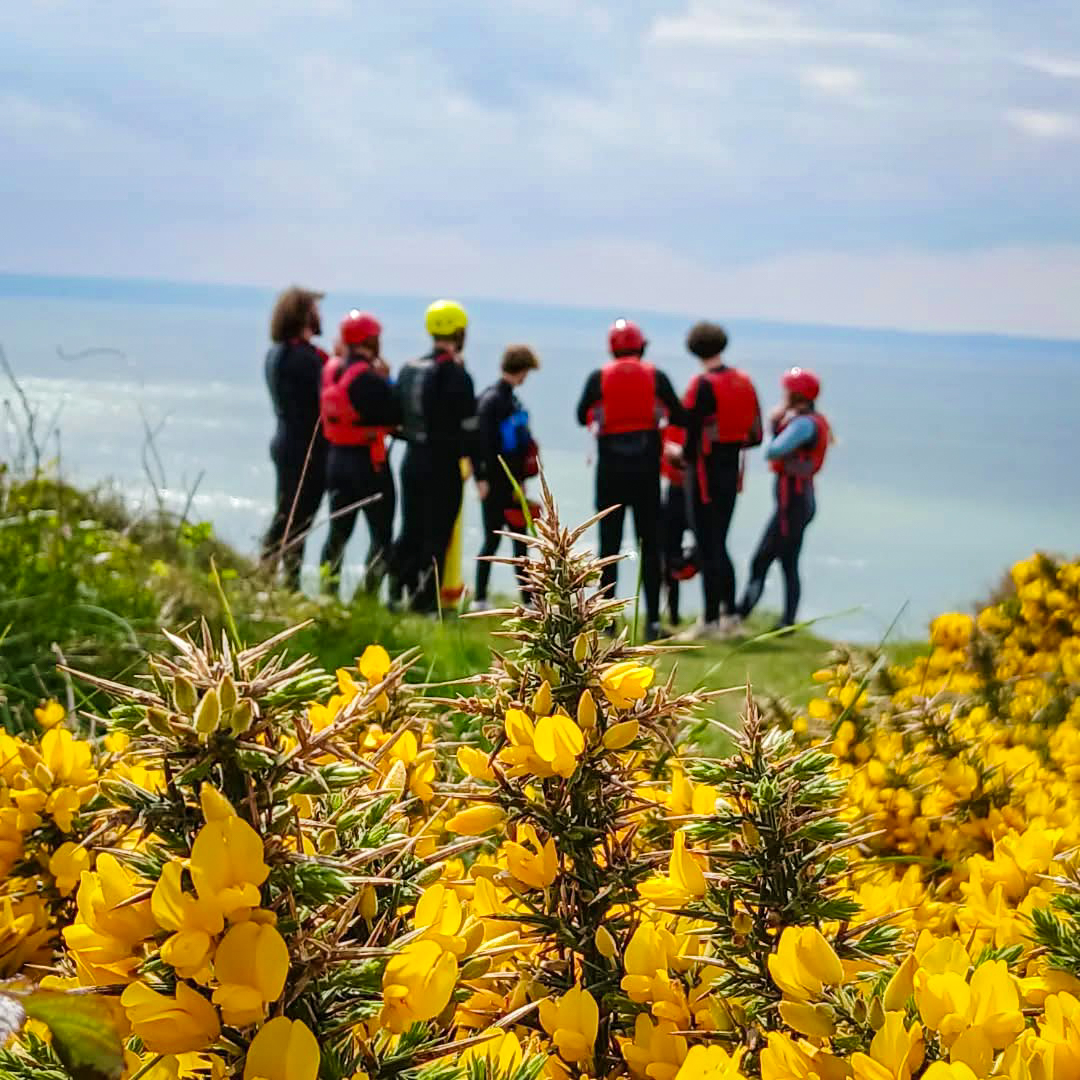 Outdoor adventure students looking out ahead of the view of the sea