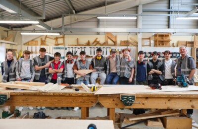 Group of construction students leant/ sat on a bench