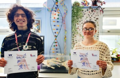 Two students holding certificates